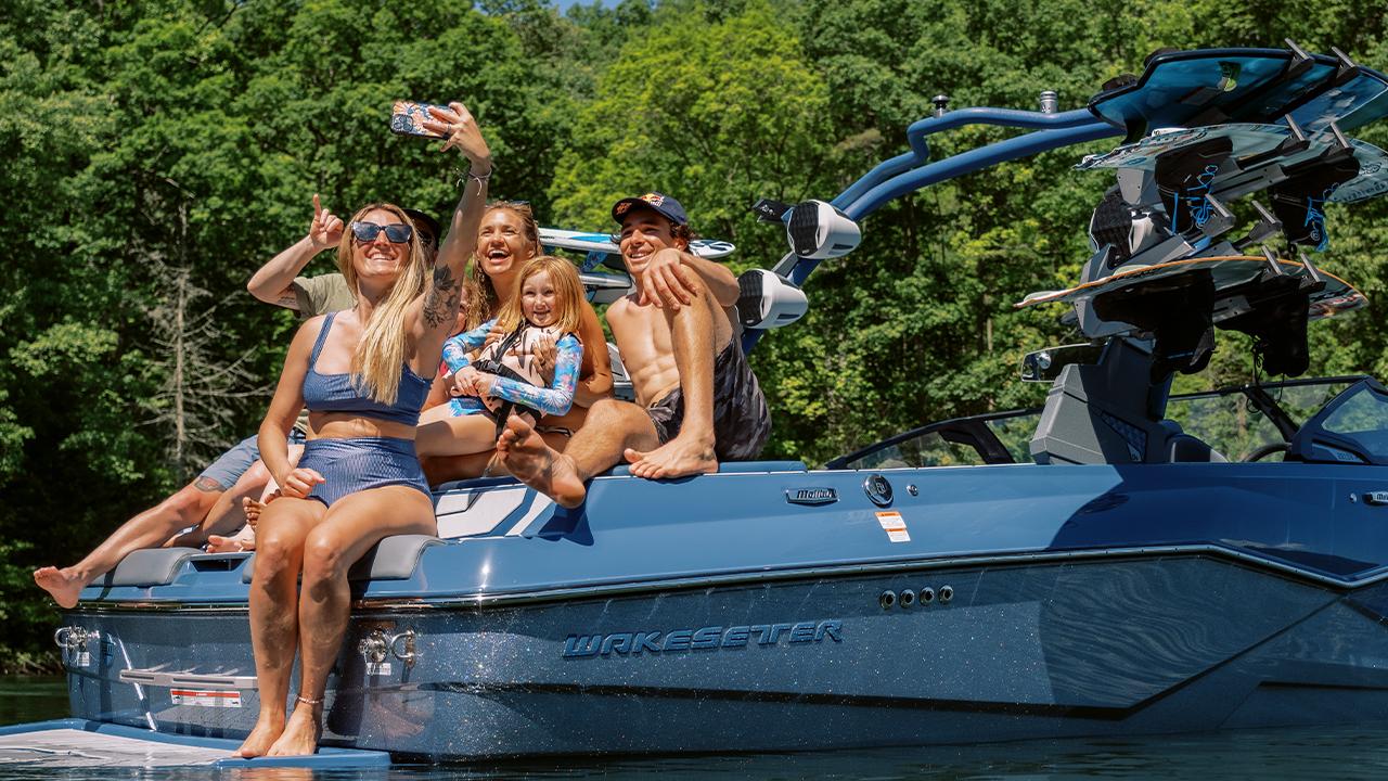 Wake boat with tower speakers on the water